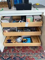 Photo of three wooden drawers open showing a large collection of CDs and some DVD cases stacked and organized.