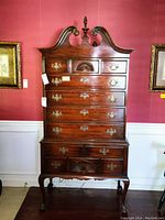 Front view of full tallboy dresser showing carved top, drawers, hardware and overall condition