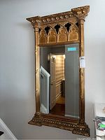 Full front view of the large rectangular framed bevelled mirror with decorative gold frame, showing overall size and wall mounting.