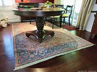 Rectangular wool rug under round dining table on hardwood floor, showing overall size and pattern.