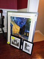 Overall view showing all three framed pieces against a wall and floor with chairs nearby, giving scale and presentation context.