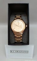 Photo of R.J. Graziano rose gold tone bracelet watch in original black box, showing watch face and bracelet on foam cushion.