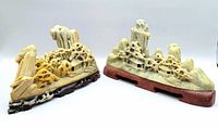 Two vintage Asian soapstone landscape village carvings side by side on wooden bases, showing overall size and style for the lot.