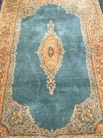 Close-up photo showing central medallion in blue with decorative beige and tan border.
