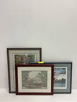Three framed art lithographs grouped together showing different scenic themes: wildlife, cityscape, and seascape.