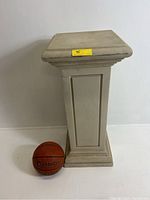 Side view of the architectural resin pedestal plant stand with a basketball for scale showing approximate height and width.