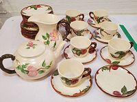 Photo showing the entire Franciscan Apple Pattern tea set including teapot, pitcher, teacups with saucers, and plates arranged on table