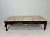 Full view of mid-century coffee table showing marble top and carved wooden frame.
