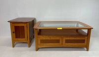 Full view of the oak nightstand and coffee table set with glass top and drawers
