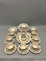 Front view of 38-piece china set showing cups, saucers, bowls, plates, creamer, and sugar bowl with floral pattern.