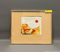 Framed watercolor painting showing semi-abstract sunny landscape with a prominent red sun shape.