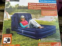 Photo of sealed box showing the airbed with backrest and usage outdoor scene.