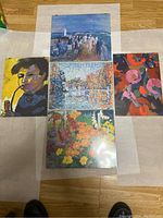 Overview of five mounted prints laid on floor showing various colorful copies of famous artworks.