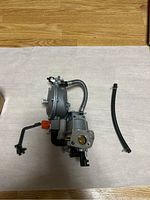 Top view of propane adapter main unit with attached hoses and separate black hose.