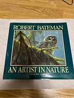Front cover of 'Robert Bateman An Artist in Nature' book showing an owl illustration with dark green background and gold text.
