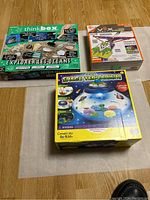 Photo showing three boxed children's activity kits: ThinkBox Explorer Les Oceans, VEX Robotics, and Creativity for Kids Crystal Space Terrarium.