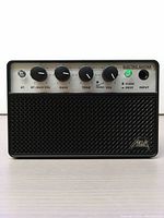 Front view of AKLOT mini guitar amplifier showing control panel with knobs and input jack