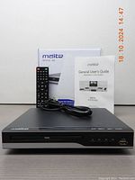 Front view of Meita MTDVD-8A DVD/CD player with remote, power cord, user manual, and box.