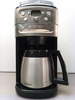 Front view of the Cuisinart coffee maker showing the stainless steel finish, control panel, and thermal carafe in place.