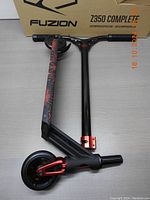 Fuzion Z350 Pro Scooter folded and placed on a surface, showing the overall scooter and the box behind.