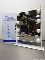 Photo of Dirket LED lighted makeup mirror on white stand with box behind it showing model and branding.