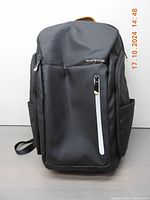 Front view of black Ponhog laptop backpack showing main zipped compartments and branded logo