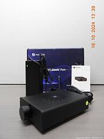 Fosi Audio V3 stereo amplifier front and side view with power adapter and manual alongside blue retail box