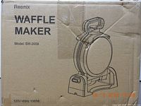 Box showing front of waffle maker with product name, model SW-2009, power rating 120V-60Hz 1080W, and illustration of the rotating waffle maker.