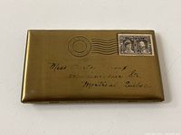 Front view of brass envelope cigarette case showing overall design