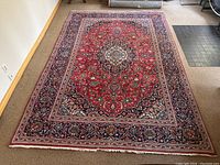 Full front view of rug laid out showing central medallion and border pattern