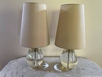 Front view of both crystal lamps with shades on marble surface