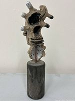 Front view of abstract sculpture on wood base showing overall design