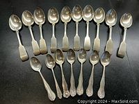 Top-down view of all 17 teaspoons laid out on a surface showing overall quantity and variation.