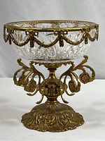 Full view of vintage cut glass bowl with ornate gilt metal pedestal stand, showing detailed base and curved metal elements.