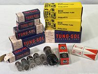 Electron tube boxes and loose tubes grouped on table, various brands and models visible including Tung-Sol and Philips ECG