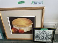 Framed still life painting showing a soufflé with two apples, gold frame with white matting