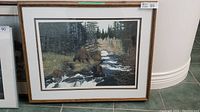 Framed limited edition print titled 'Watchful Eye' showing a mother bear and three cubs near a stream in a wooded area, with a cream and gold mat and wooden frame with gold trim.