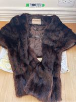 Front view of brown lined fur shawl laid flat, showing fur texture and collar area.