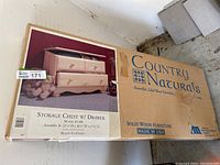 Boxed Country Naturals storage chest with drawer, showing packaging and product image.