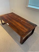 Photo showing the full rectangular cherrywood coffee table with visible wood grain and natural finish. Blemish on table surface is visible.