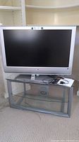 Sony Bravia 40 inch flat screen TV on glass and metal frame TV stand