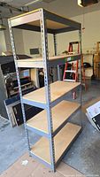 Full front angle view of the steel shelf unit showing four wooden shelves and steel frame.