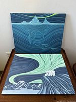 Pair of paintings showing the polar bears under Northern Lights and narwhals under iceberg with Northern Lights.