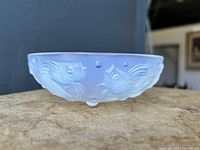 Front angled view showing opalescent finish and raised fish motif