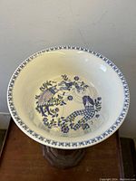 Top down angled photo of the serving bowl showing interior design of dancing couple and floral pattern.