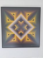 Full view of the signed geometric print in a black frame, mounted on a wall.