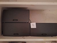 Three Sonos Play:3 speakers on shelf showing front grilles and logos
