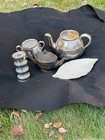 Group display of 5 items on black cloth outside on grass.