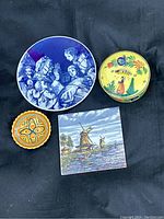 Overhead view of four collectible ceramic and porcelain decorative pieces showing distinct styles