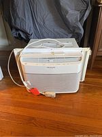 Front view of Frigidaire Gallery window air conditioner unit showing white plastic casing, front grille, and power cord.